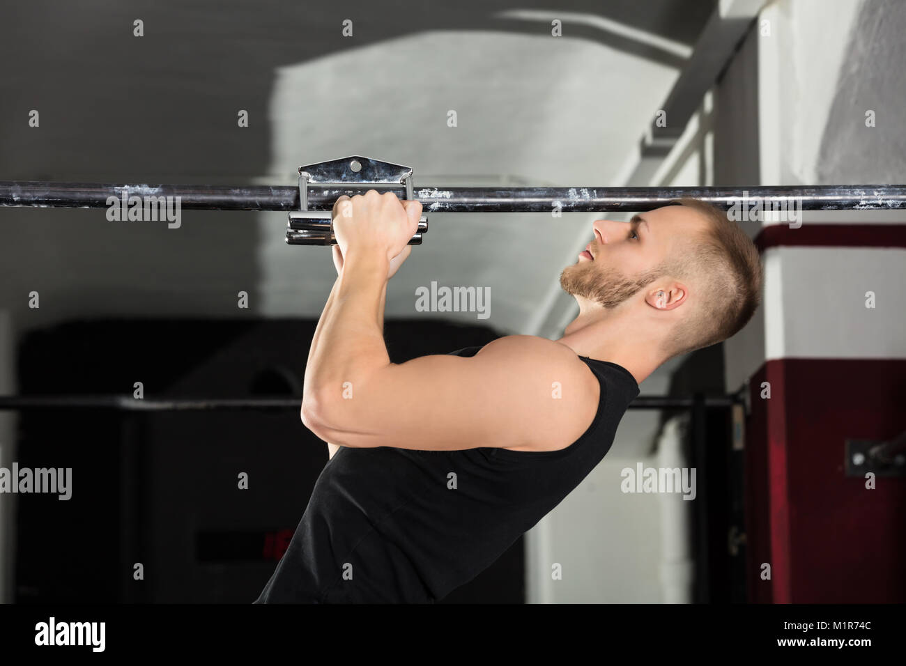 Close-up di un atleta uomo facendo presa stretta Pullup esercizio in palestra Foto Stock