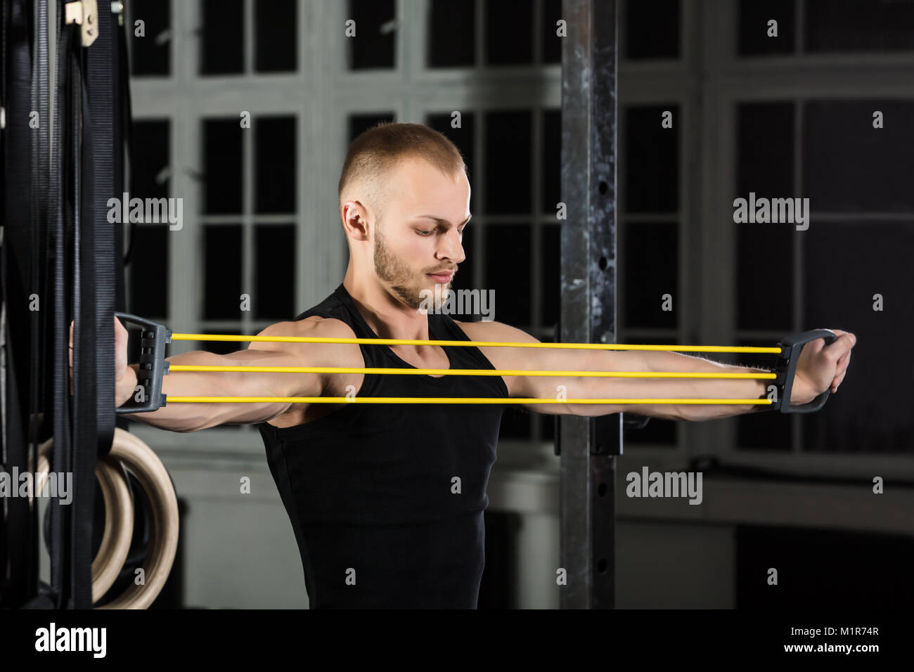 Ritratto di un atleta uomo che lavora con fascia elastica in palestra Foto Stock