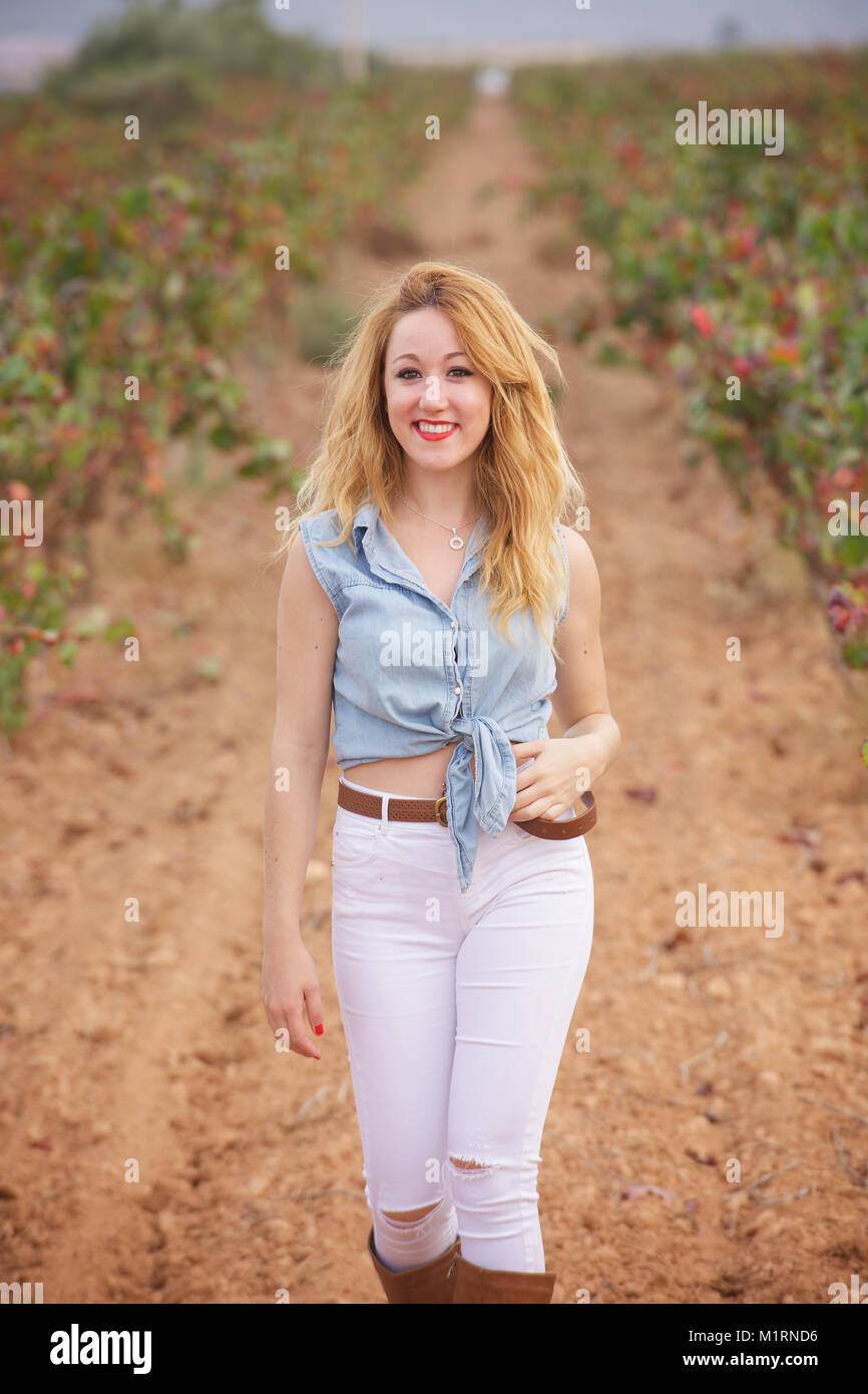Bella ragazza che indossa jeans stretti e stivali nei pressi di un vigneto  Foto stock - Alamy