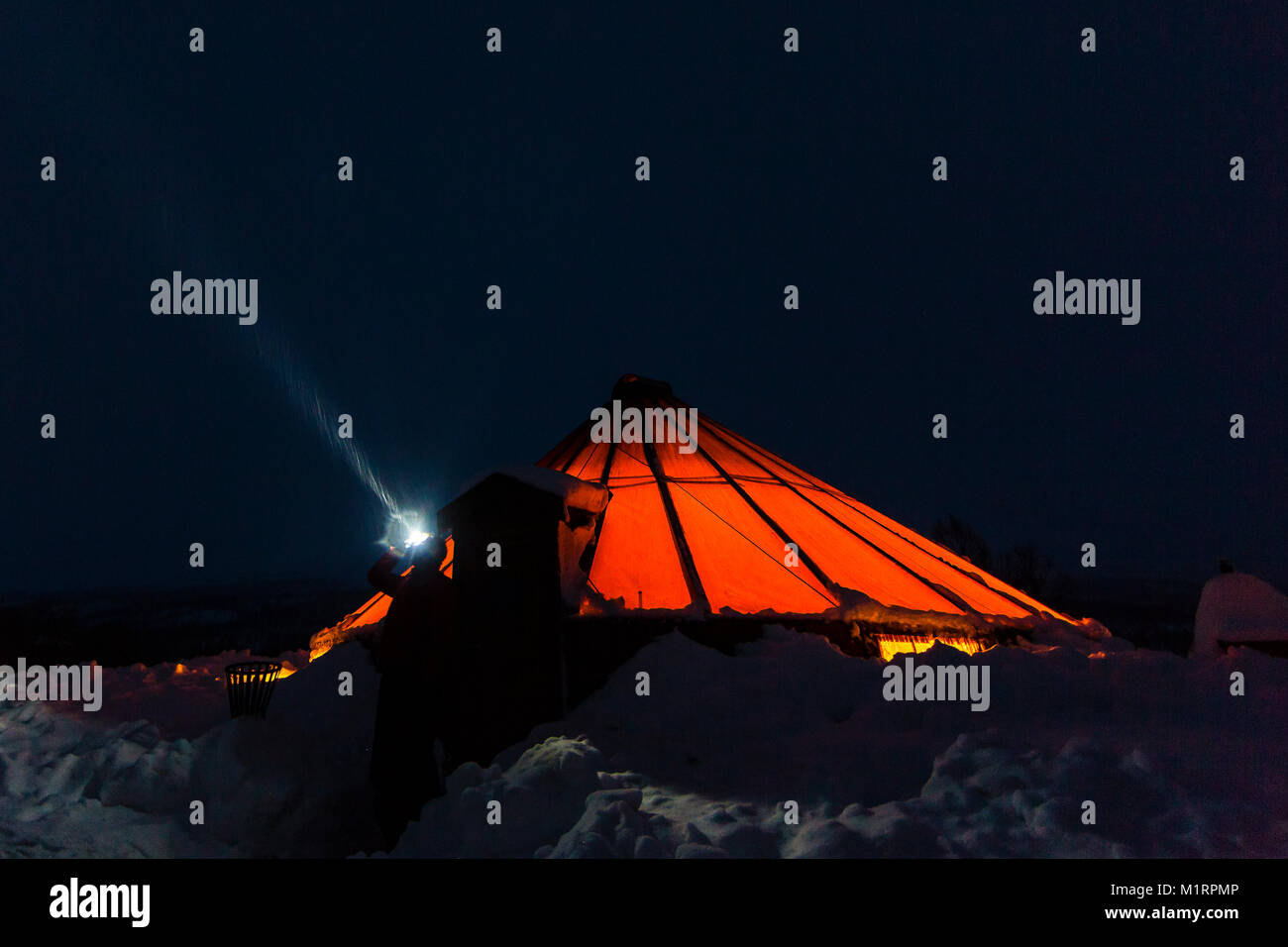 La Norvegia. Fotografo Dave Stevenson indossando la torcia da testa al di fuori del tradizionale norvegese tenda lavvu. Foto Stock