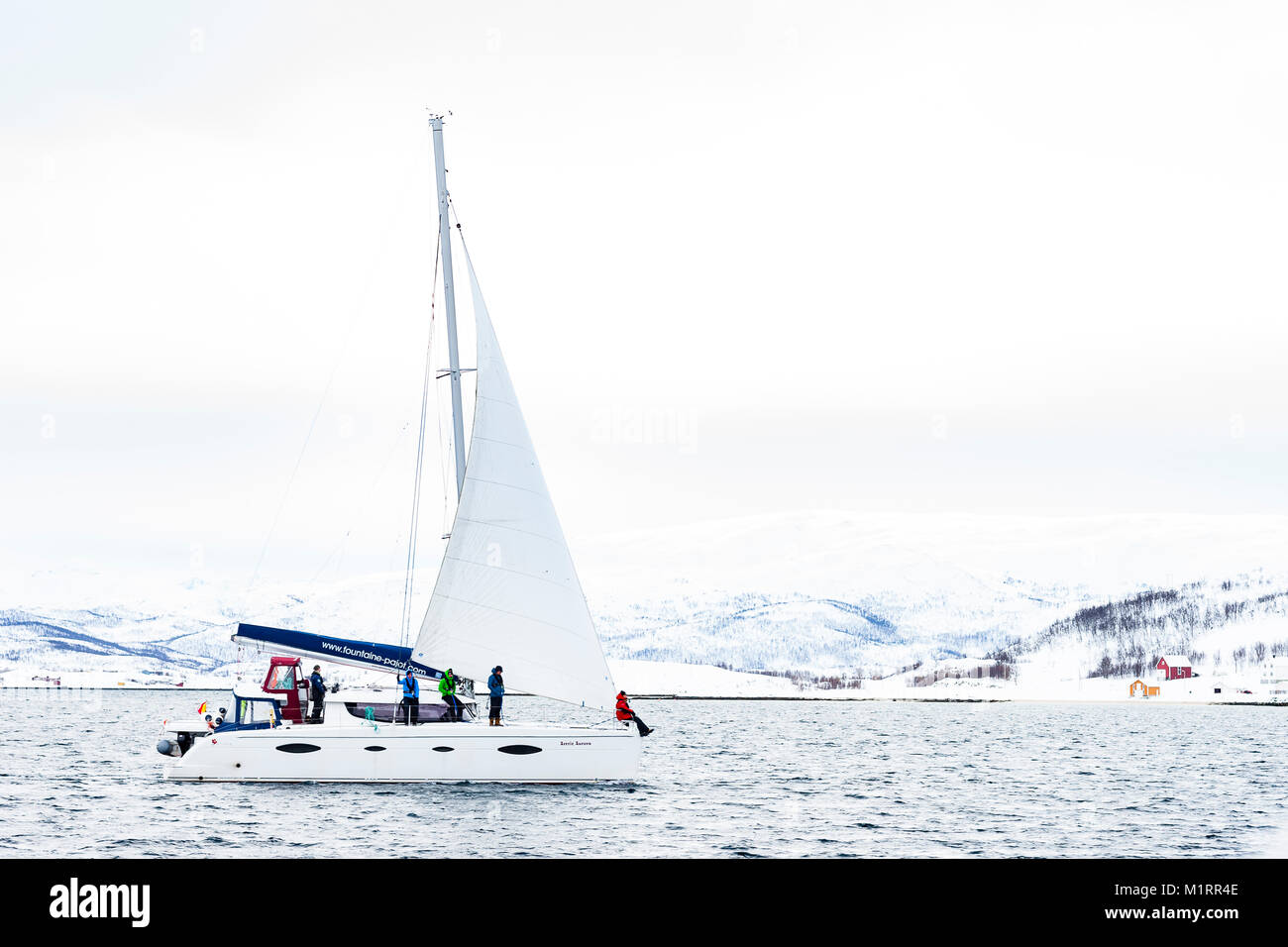 La Norvegia. Catamarano a vela in mare calmo con la costa norvegese dietro. Foto Stock