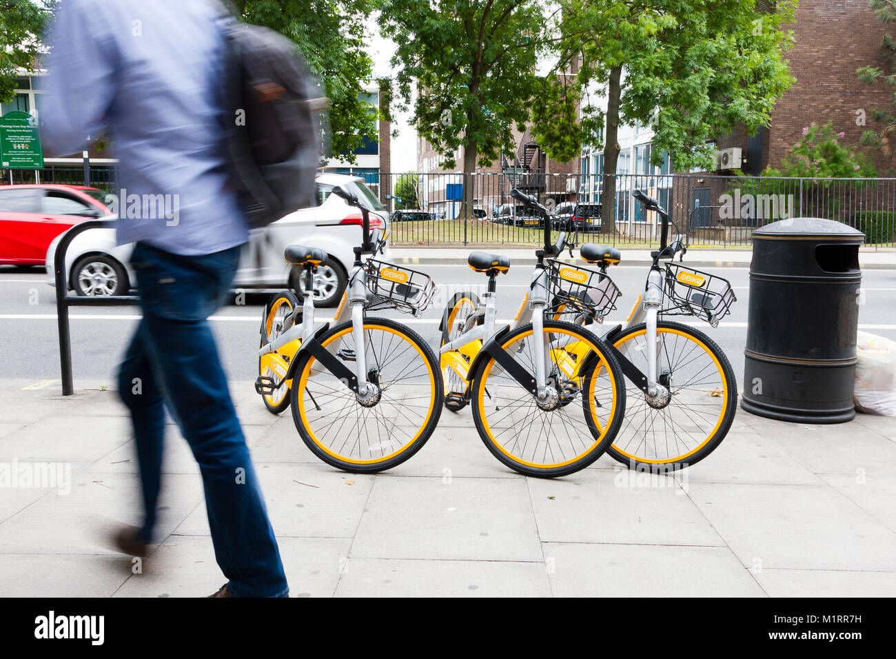 Londra, Inghilterra. Uomo che cammina passato tre Obikes seguendo il servizio di lancio travagliato a Londra. Foto Stock