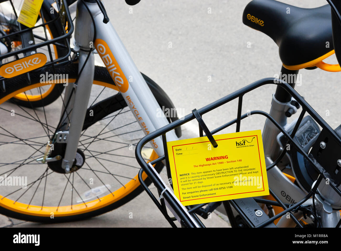 Londra, Inghilterra. Giallo applicazione preavviso su un Obike in Fulham rilasciato da Hammersmith e Fulham consiglio avvertenza che la moto è una ostruzione. Foto Stock