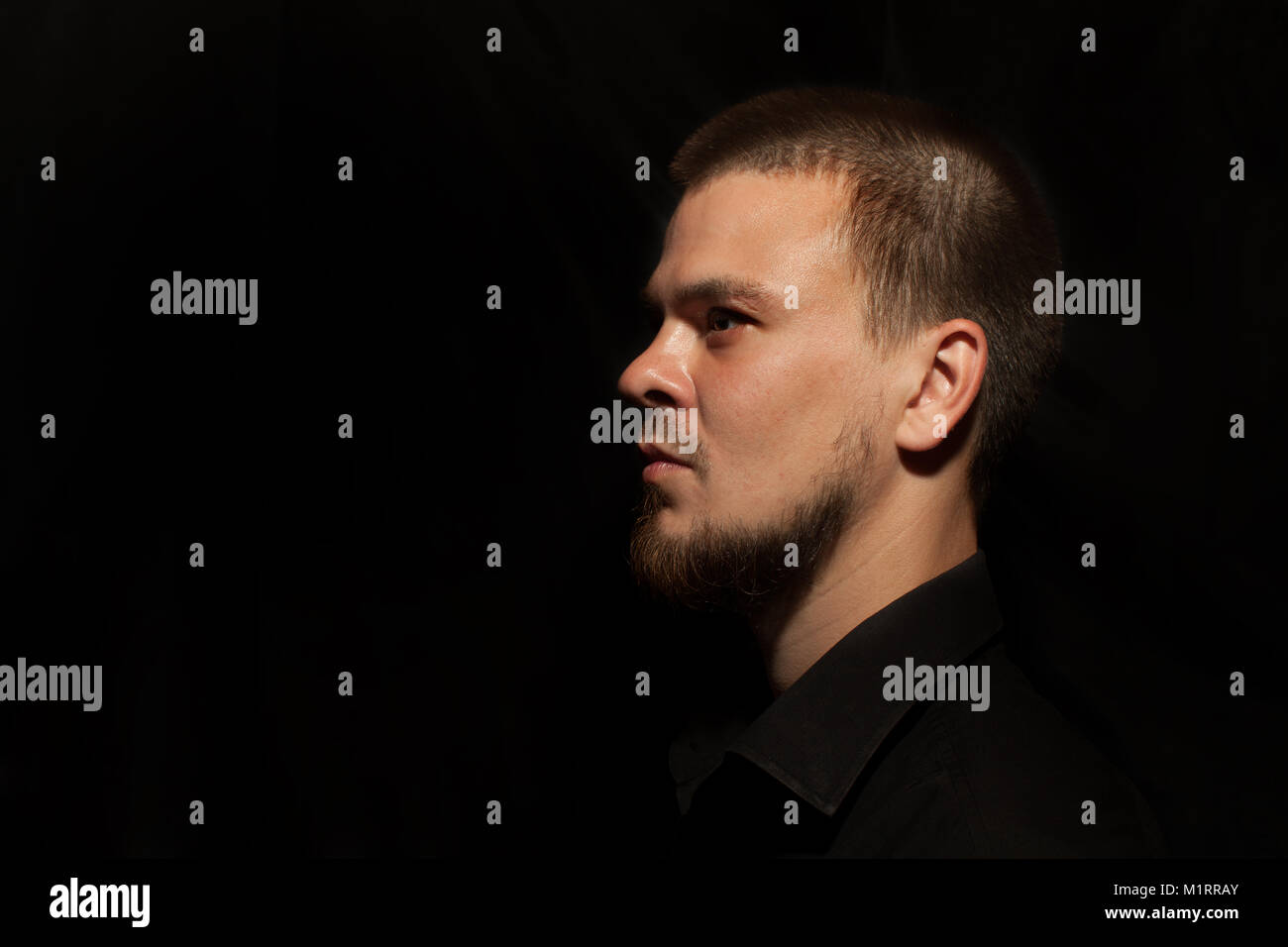 Ritratto di un uomo su uno sfondo nero. giovane uomo close up ritratto, su sfondo nero Foto Stock