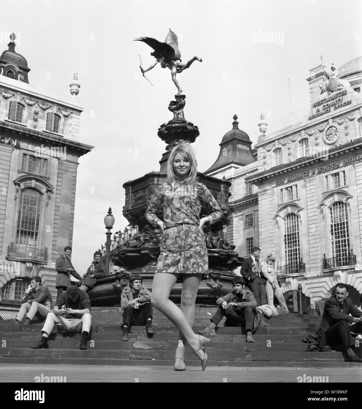 Un modello pone in un mini dress all'aperto a Londra Piccadilly vicino alla statua di Eros in circa 1968 indossa un colorato Mini-abito. Foto di Tony Henshaw Foto Stock