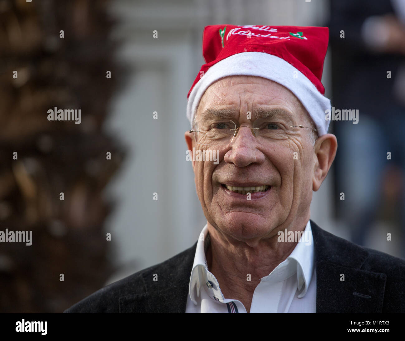 Close-up in posa con un berretto di Babbo Natale nel giardino della casa Foto Stock