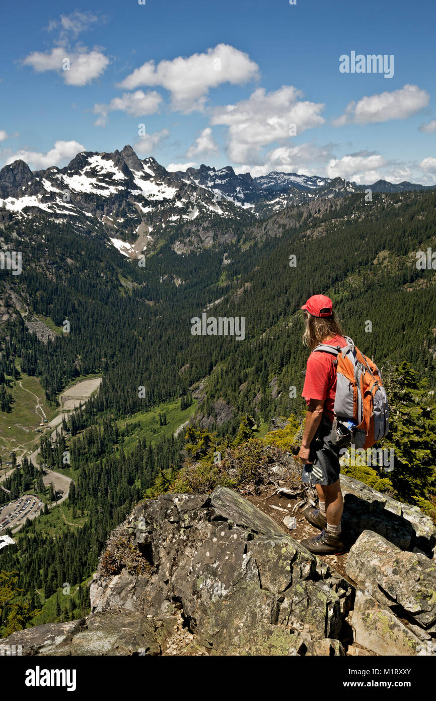 WA13210-00...WASHINGTON - escursionista sul vertice del nord di Guye a picco sul Alpental Ski Area e sedia picco nel monte Baker-Snoqualmie Nazione Foto Stock