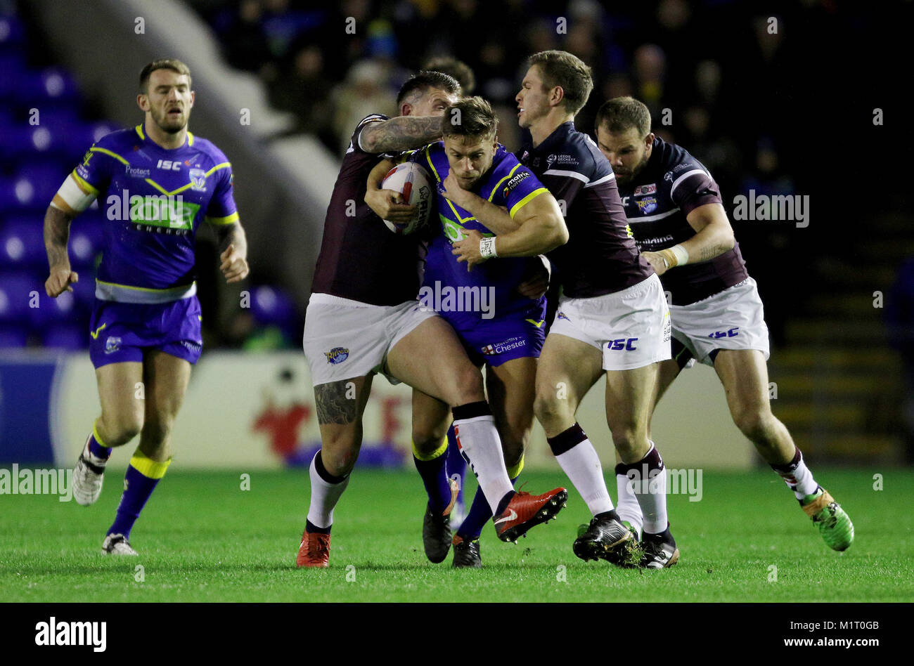 Warrington's Matty Russell viene affrontato da leeds rinoceronti durante il Betfred Super League match al Halliwell Jones Stadium, Warrington. Foto Stock