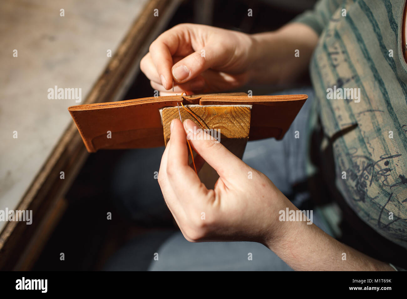 Close up di mani tanner svolge un lavoro sul tavolo con gli attrezzi Foto Stock