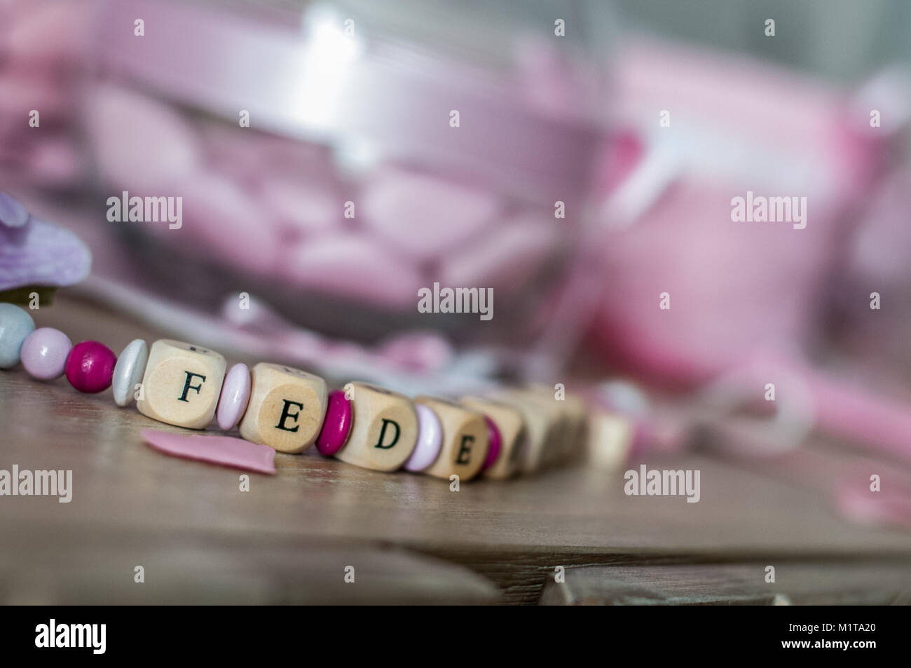 Ragazza neonata tabella set con contenitori in vetro con differenti rosa confetto e doudou denominato federica Foto Stock