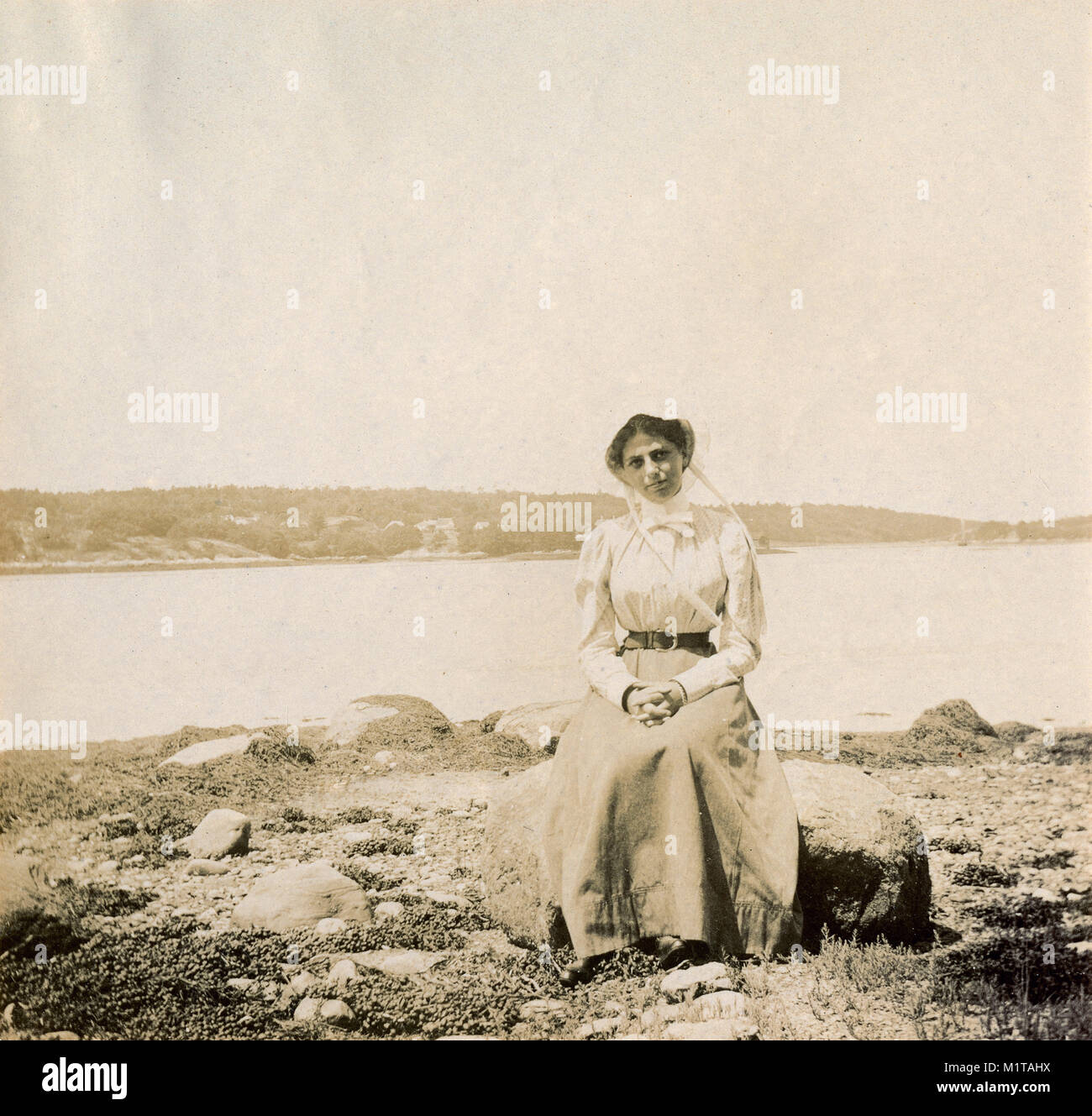 Antique circa 1905 fotografia, donna su una roccia nei pressi della bassa marea a Sasanoa fiume. La posizione è in o vicino a Riggsville (ora Robinhood), Maine in Sagadahoc County, Stati Uniti d'America. Foto Stock