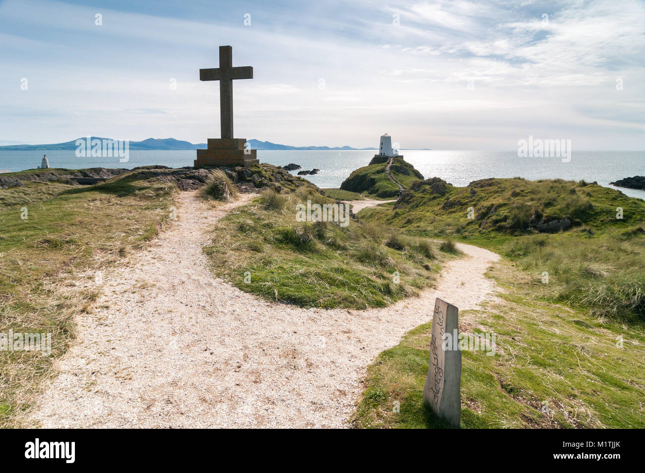 Una grande croce di legno e Tŵr Mawr faro sull isola di Llanddwyn su un soleggiato nella tarda estate del giorno, Anglesey, Galles Foto Stock