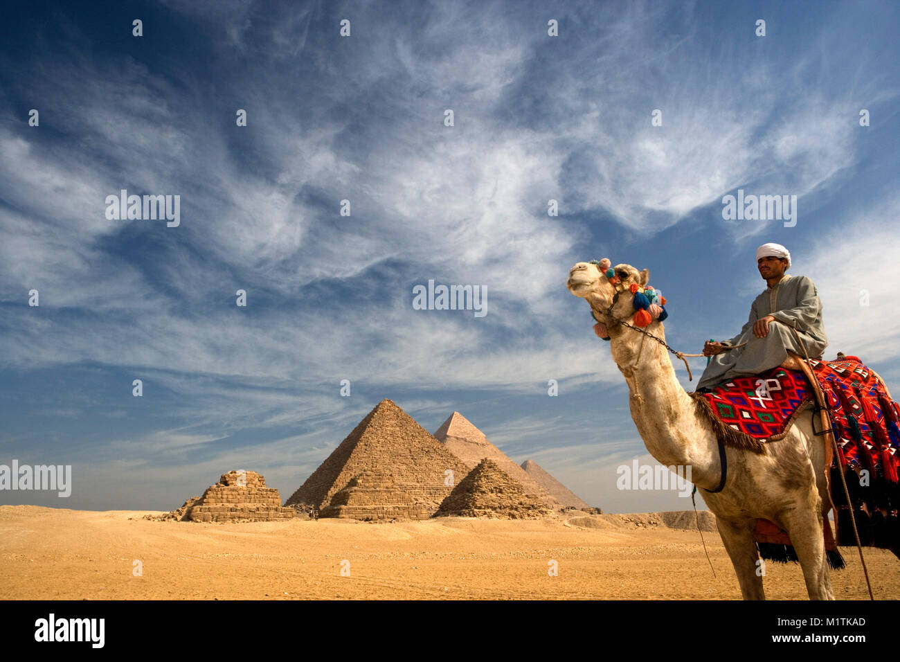 L'Egitto, al Cairo. Piramidi di Giza o Giza. L'uomo, camel driver sul cammello nel deserto vicino a piramidi. Unesco World Heritage Site. Foto Stock