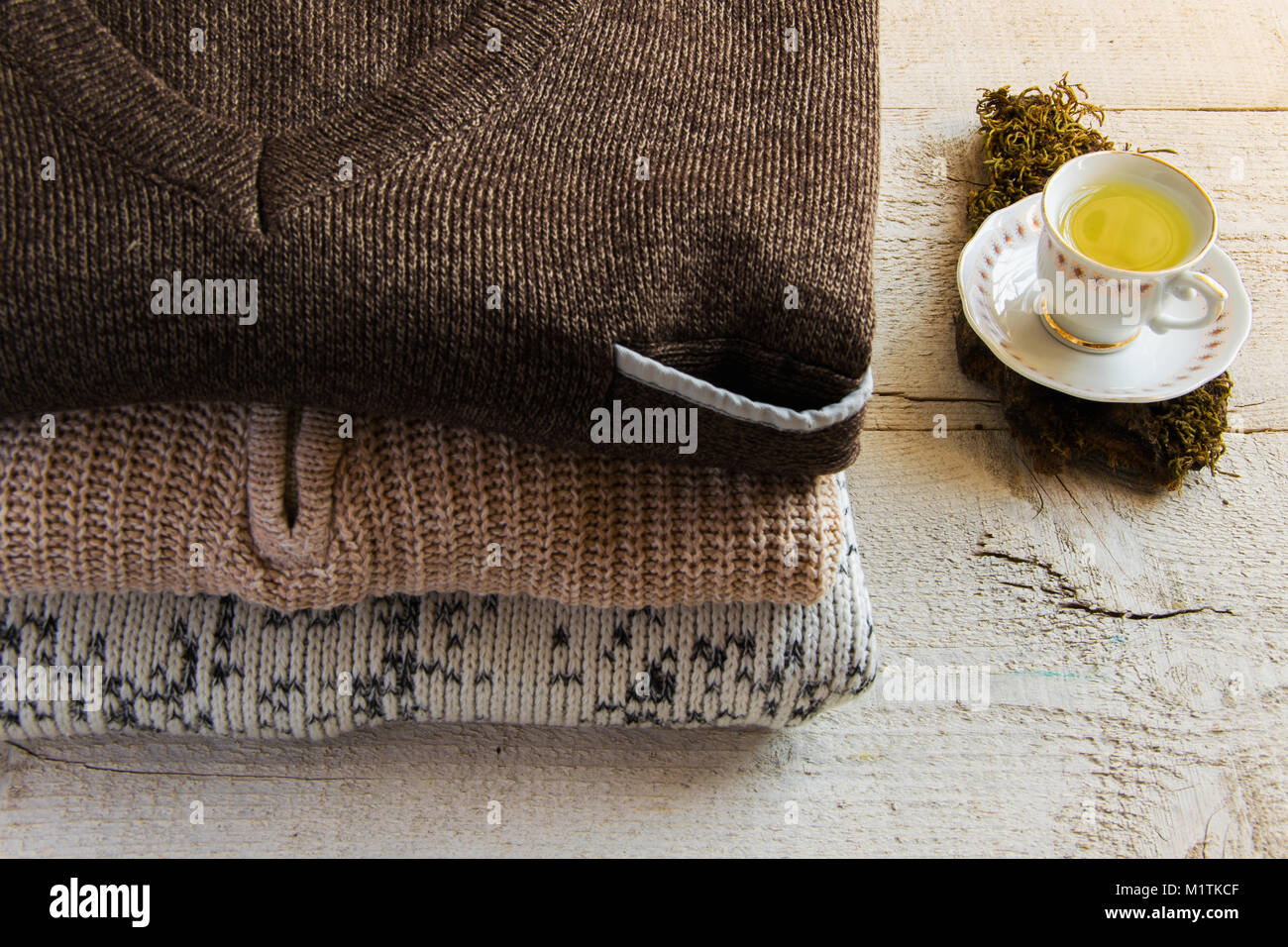 Caldo e accogliente a maglia Maglioni Maxi e la tazza di tè su sfondo di legno con spazio per il testo. Concetti - moda, confortevole il tempo trascorso a casa Foto Stock