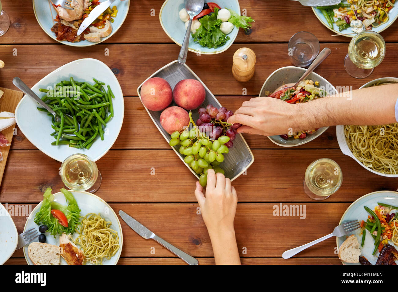 Gruppo di persone mangiare a tavola con i prodotti alimentari Foto Stock