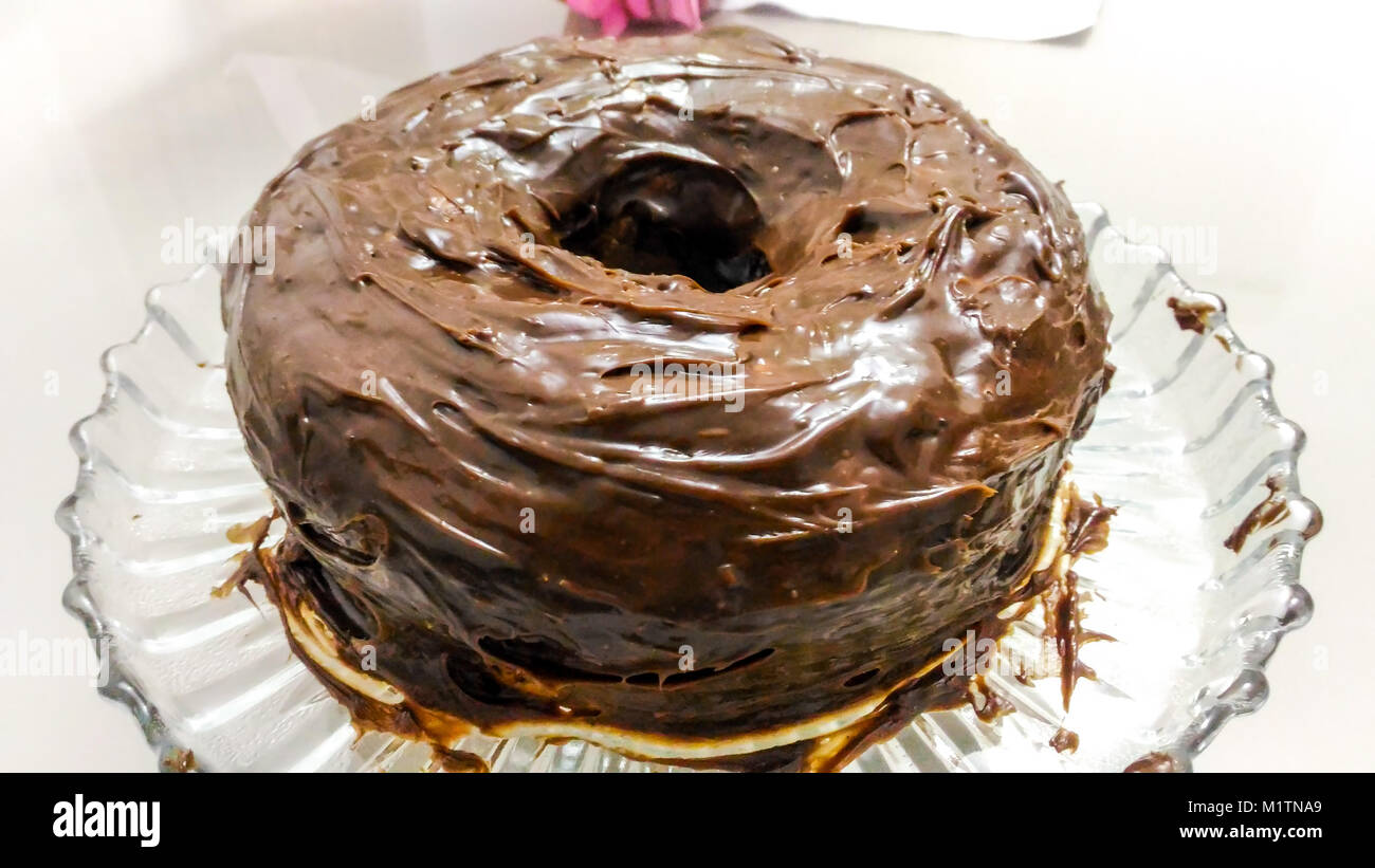 Torta al cioccolato su un vassoio di vetro con una bella topping Foto Stock