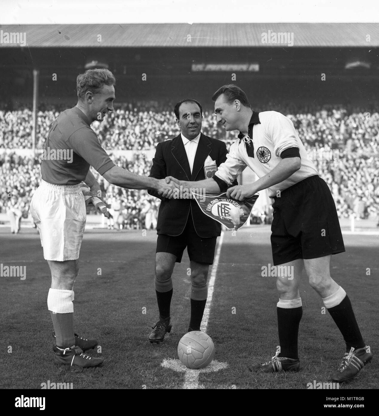 Inghilterra e Germania Ovest, Wembley Stadium 01 dicembre 1954 Inghilterra capitano Billy Wright stringono le mani con il capitano della Germania Ovest Josef Posipal guardato da arbitro Vicenzo Orlandini Foto Stock