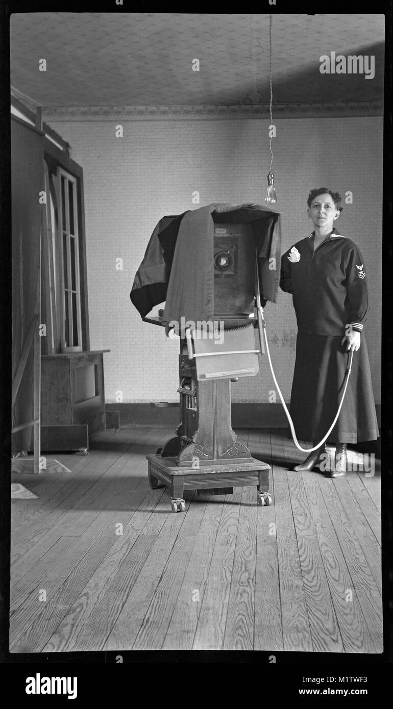 Donna con grande fotocamera in formato su supporto, circa 1900. Foto Stock