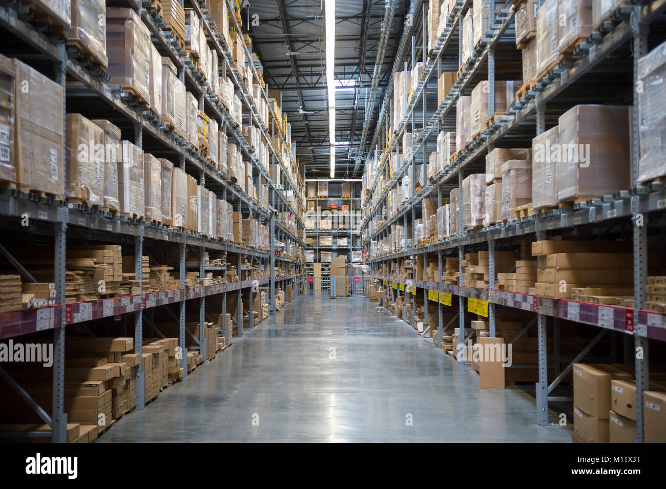 Visualizza in basso un corridoio di ben rifornita di scaffali in un magazzino Foto Stock