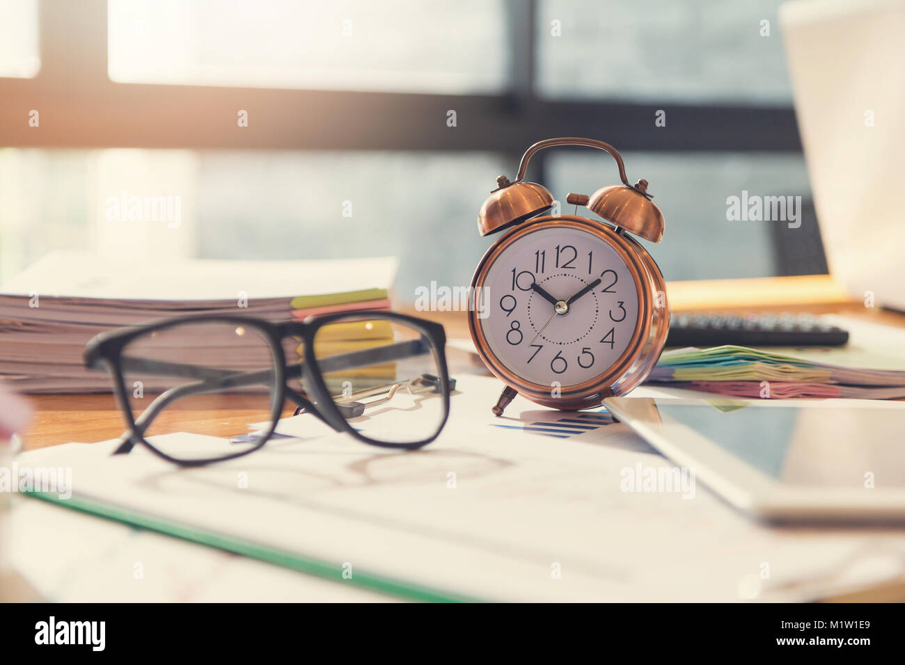 Affari e finanza concetto di ufficio a lavorare, Closeup orologio e degli occhiali sulla scrivania in ufficio Foto Stock