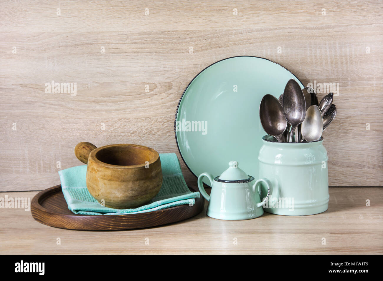 Il turchese stoviglie, posate, stoviglie e utensili da roba su piano in legno. Cucina ancora la vita come sfondo per il design. Immagine con copia spazio. Foto Stock