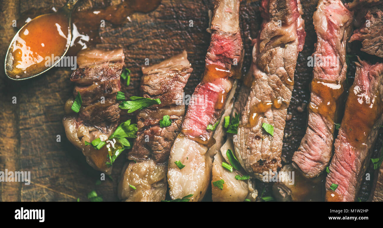 Flat-lay della bistecca grigliata di carne di manzo tagliata a pezzi Foto Stock