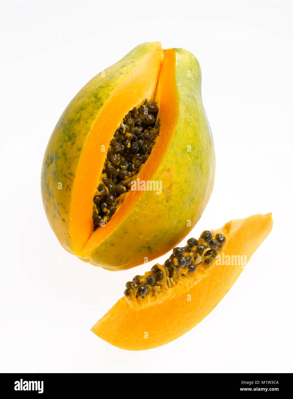 Tutta la papaia e Slice a cuneo con semi contro uno sfondo bianco Foto Stock