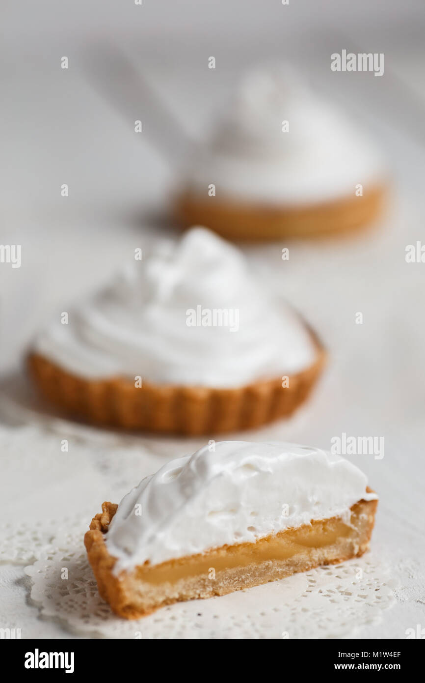 Tortine al limone con aria bianco crema contro il tavolo di legno. Foto Stock