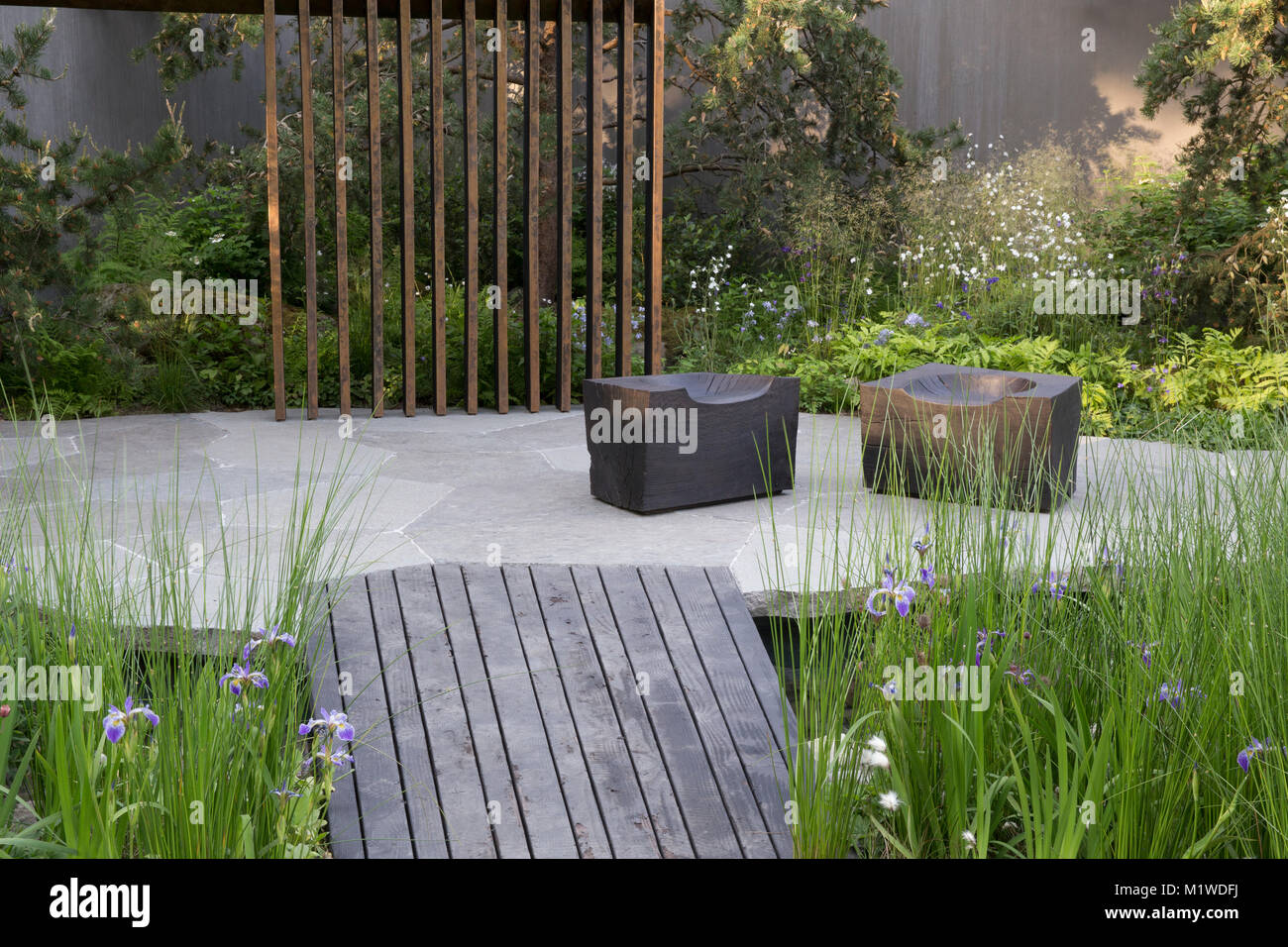Banca del Canada giardino, il Chelsea Flower Show 2018 scuro passerella in legno sulla piscina, carbonizzati cubo di legno sede Foto Stock