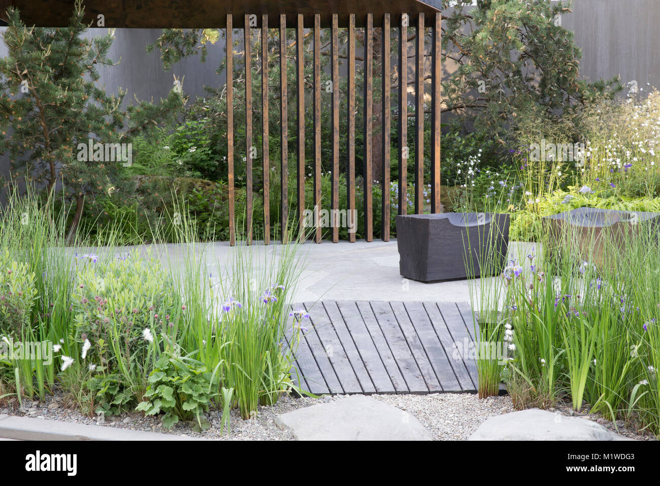 Banca del Canada giardino, il Chelsea Flower Show 2018 scuro passerella in legno sulla piscina, carbonizzati cubo di legno sede Foto Stock