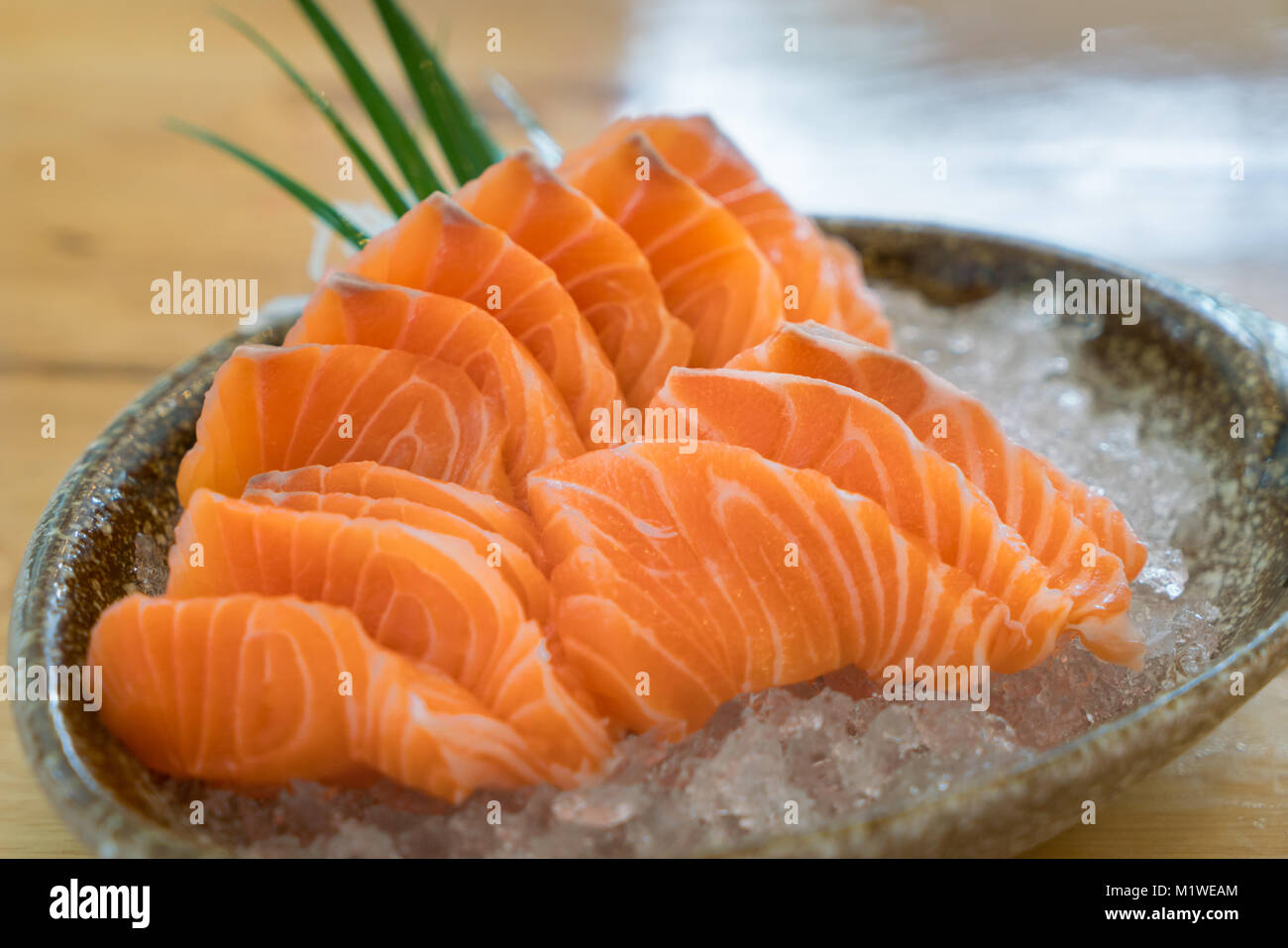 Raw fetta di salmone o sashimi di salmone in stile Giapponese servire fresco su ghiaccio in un recipiente al ristorante giapponese. Foto Stock