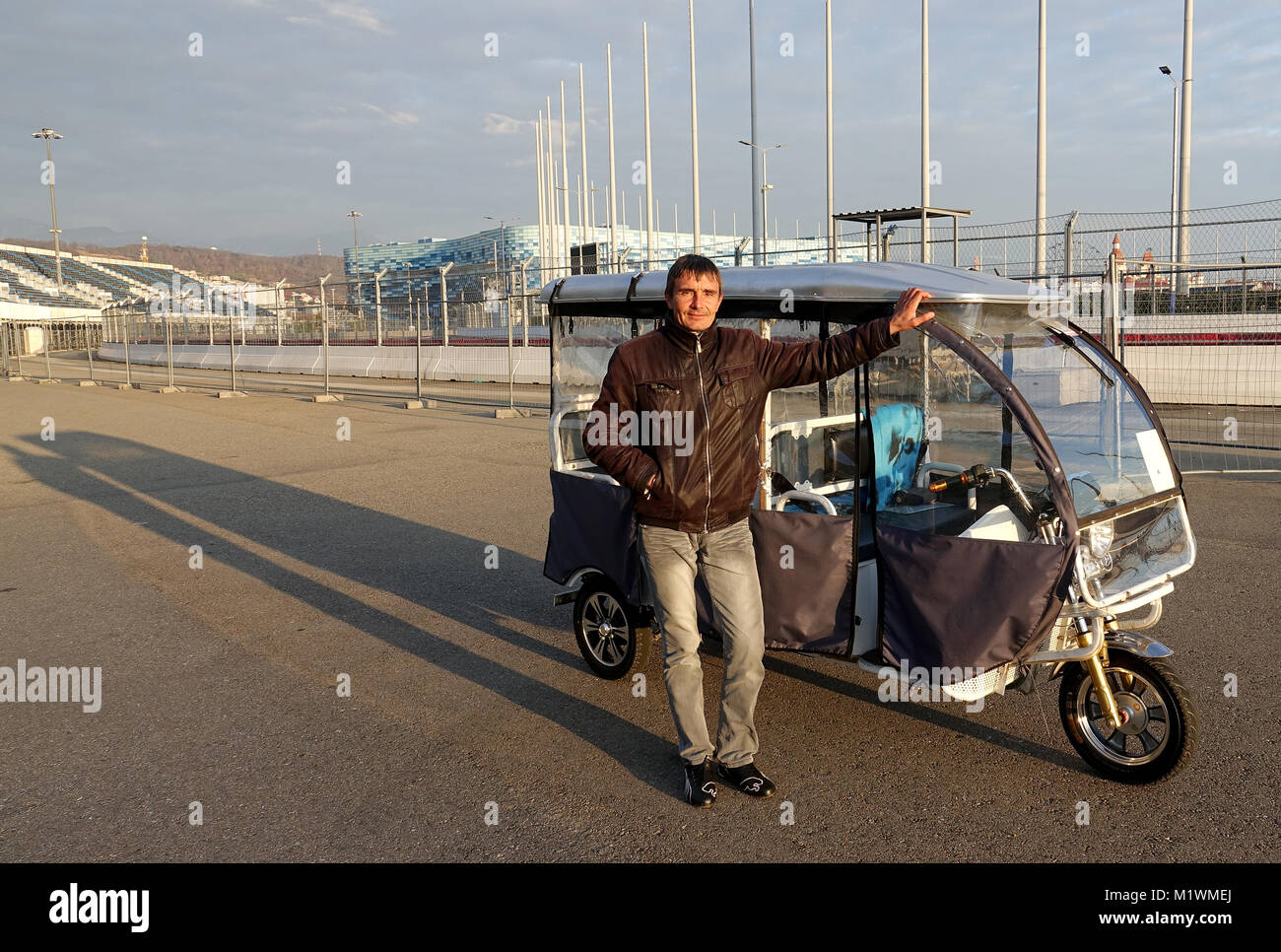 Il Russo tour guida, Alexander Scherenow, guardando la telecamera al Parco Olimpico per il 2014 Olimpiadi invernali a Sochi, Russia, 28 gennaio 2018. Egli offre gite sul suo risciò elettrico oltre i motivi del 2014 Olimpiadi Invernali. Foto: Friedemann Kohler/dpa Foto Stock