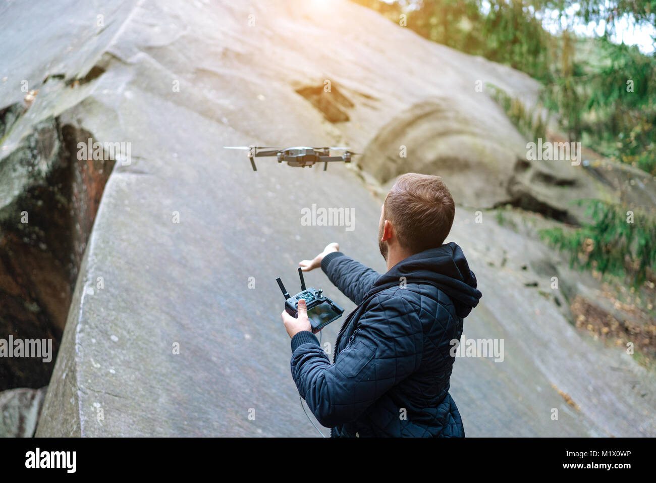 Guy inizia un quadrocopter nella foresta Foto Stock