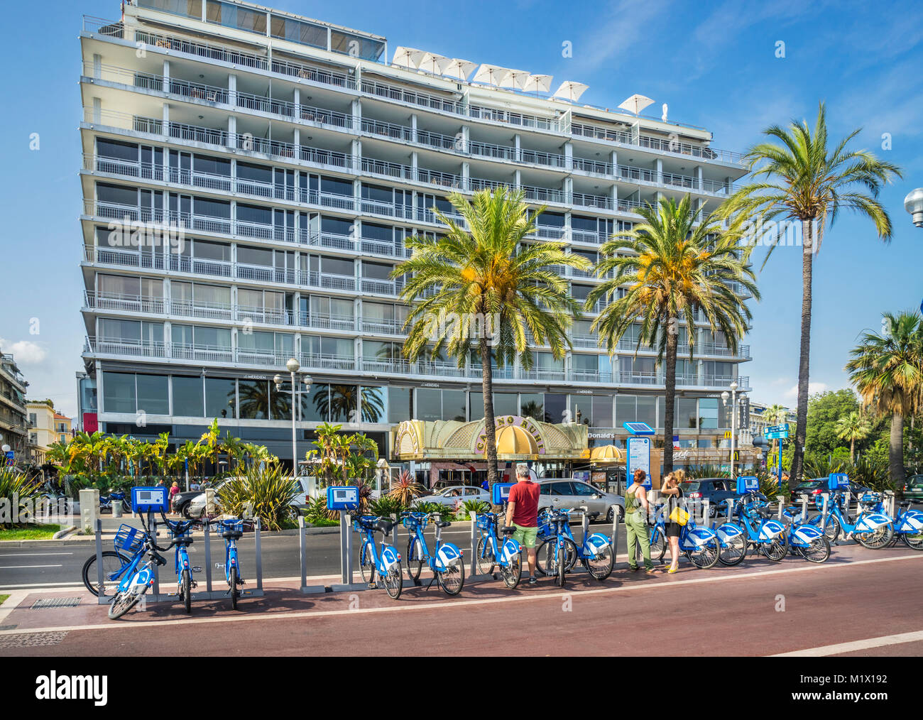 Francia, dipartimento delle Alpi Marittime, Côte d'Azur, Nizza, Vélobleu noleggio biciclette stazione al Promenade des Anglais contro lo sfondo della barra del casinò Foto Stock