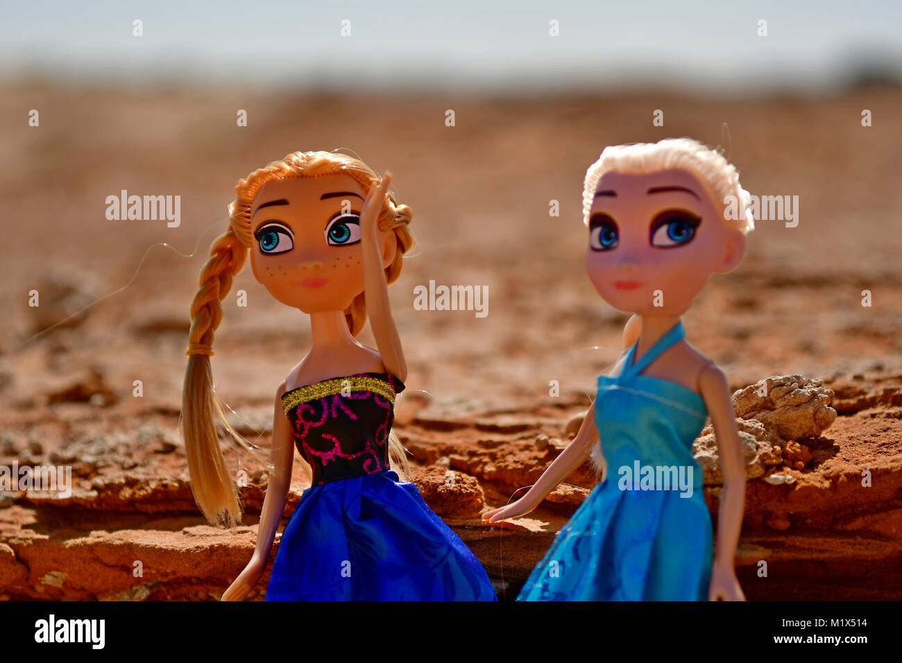 Barbie ragazze vestito di rosso e blu sono in posa per la modellazione di foto nel deserto rocce sulla posizione Foto Stock