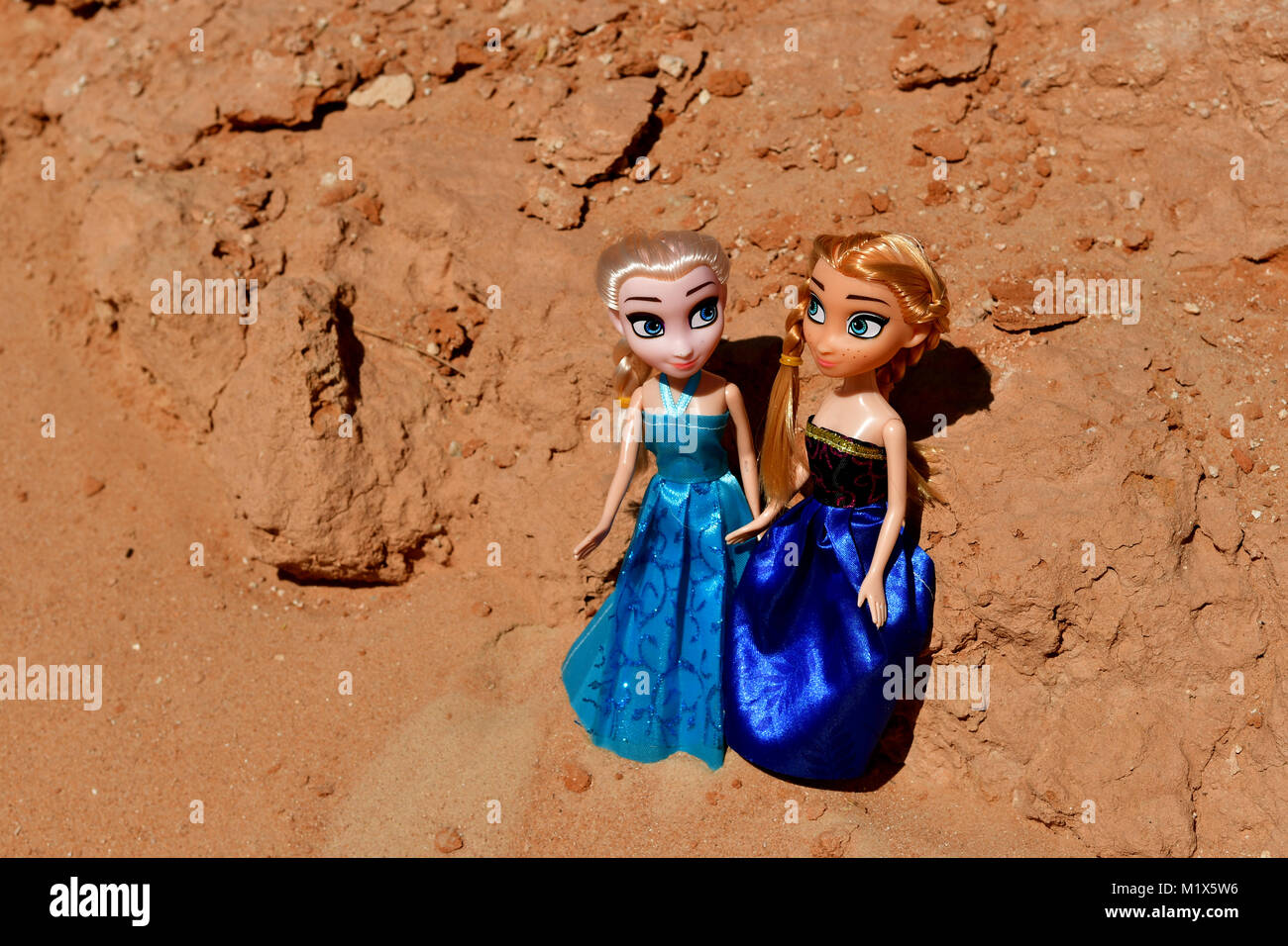 Barbie ragazze vestito di rosso e blu sono in posa per la modellazione di foto nel deserto rocce sulla posizione Foto Stock