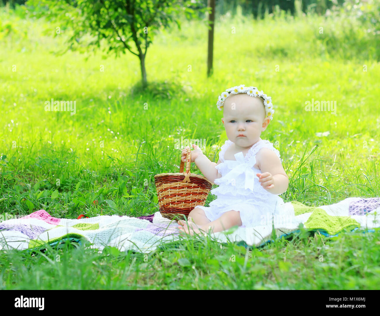 Carino il bambino in una corona di fiori su un picnic su un giorno di estate.festività ed eventi Foto Stock