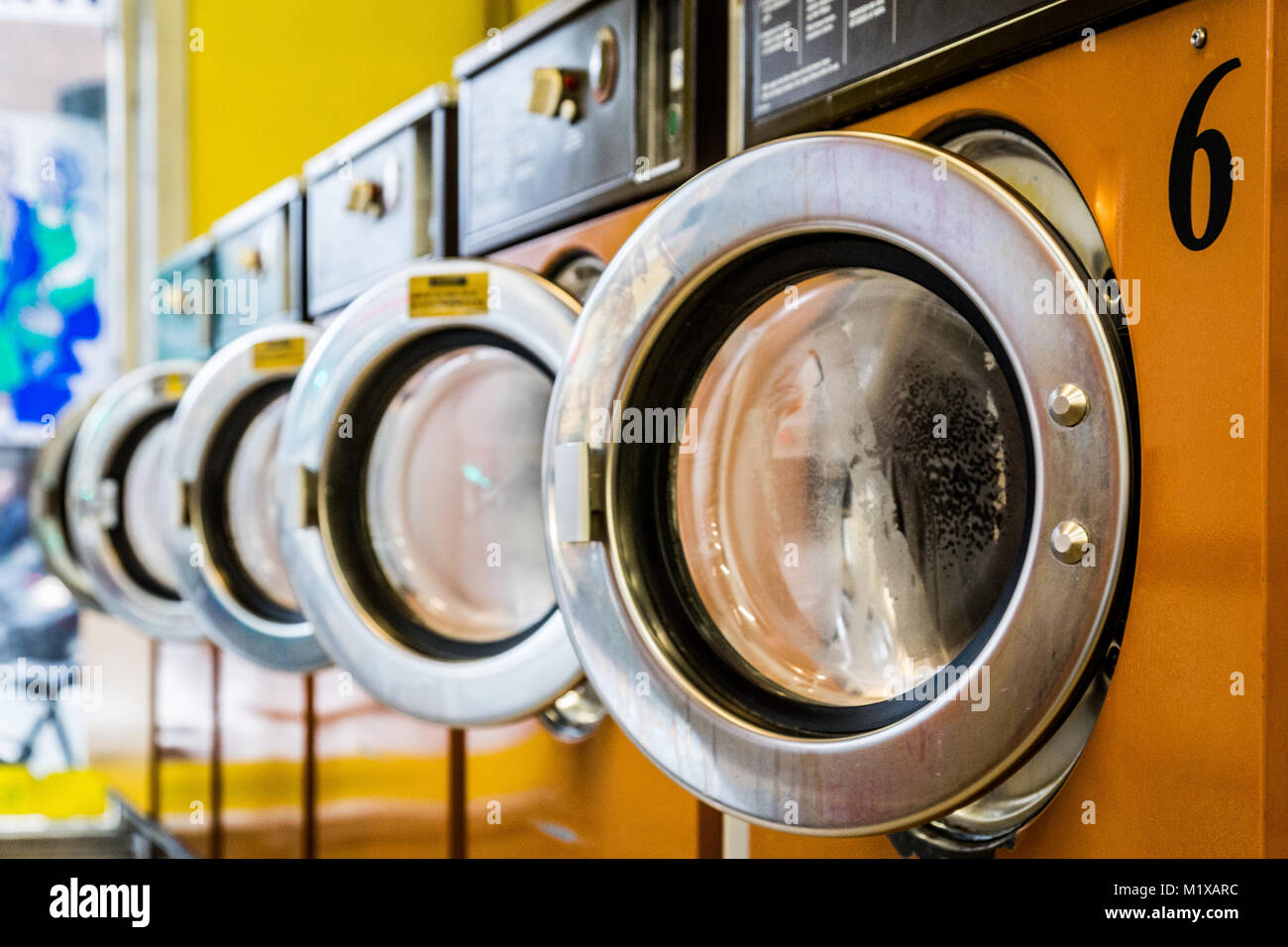 Fila di macchine di lavaggio in una lavanderia a gettoni Foto Stock