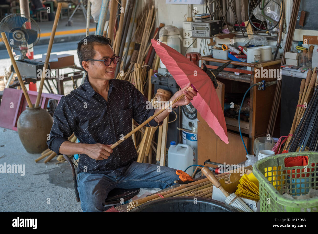Un artigiano tailandese rendendo tradizionale ombrellone a ombrello facendo centro in Bo Sang centro artigianale su San Kamphaeng Road, Chiang Mai, Thailandia. Foto Stock