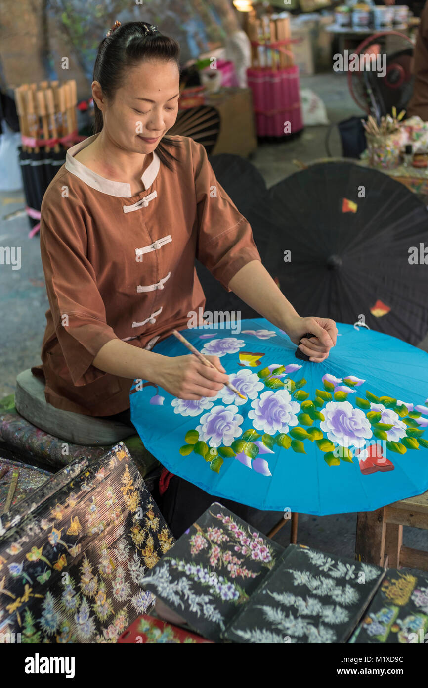 Un Thai craftswoman rendendo tradizionale ombrellone a ombrello facendo centro in Bo Sang centro artigianale su San Kamphaeng Road, Chiang Mai, Thailandia. Foto Stock