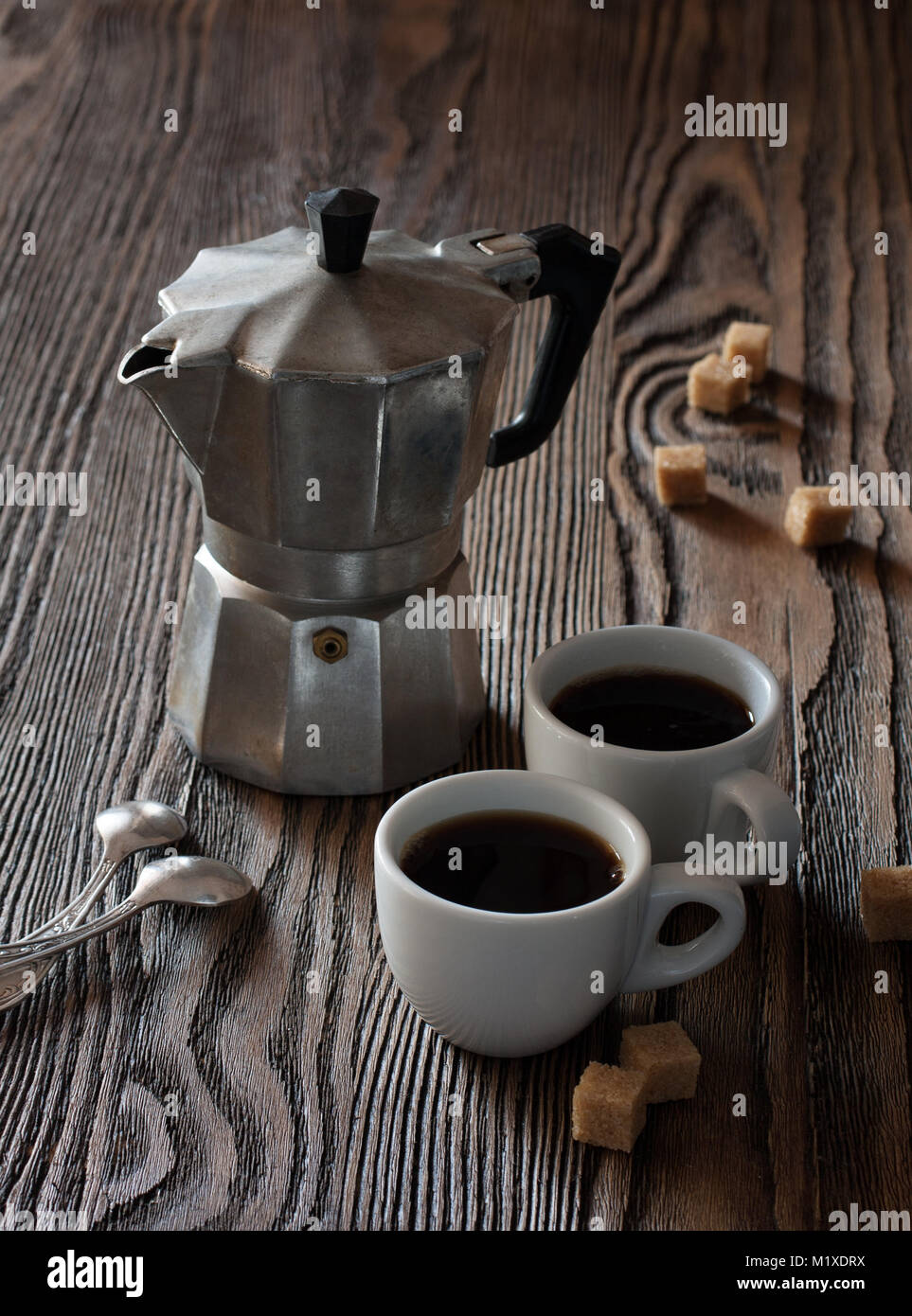 Due tazze di caffè espresso con pezzi di zucchero di canna e caffè italiano  maker su un tavolo di legno Foto stock - Alamy