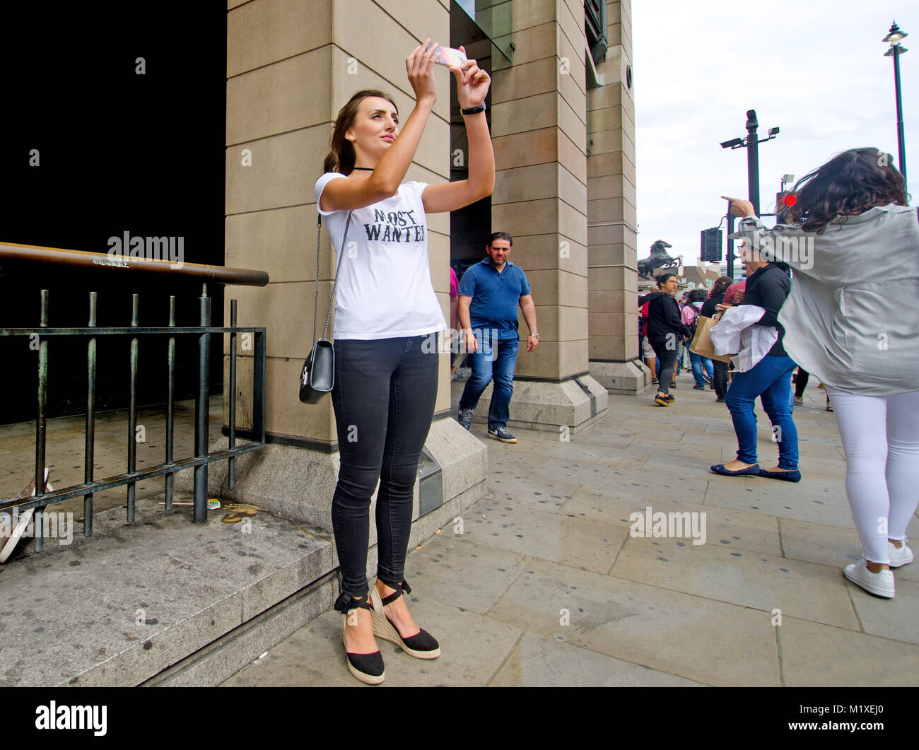 Londra, Regno Unito. Giovane donna di scattare una foto del Big Ben con il suo telefono cellulare in piazza del Parlamento Foto Stock