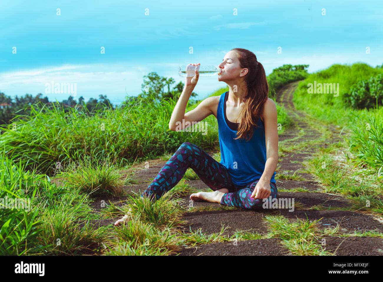 Donna bere acqua dopo il corso di formazione Foto Stock