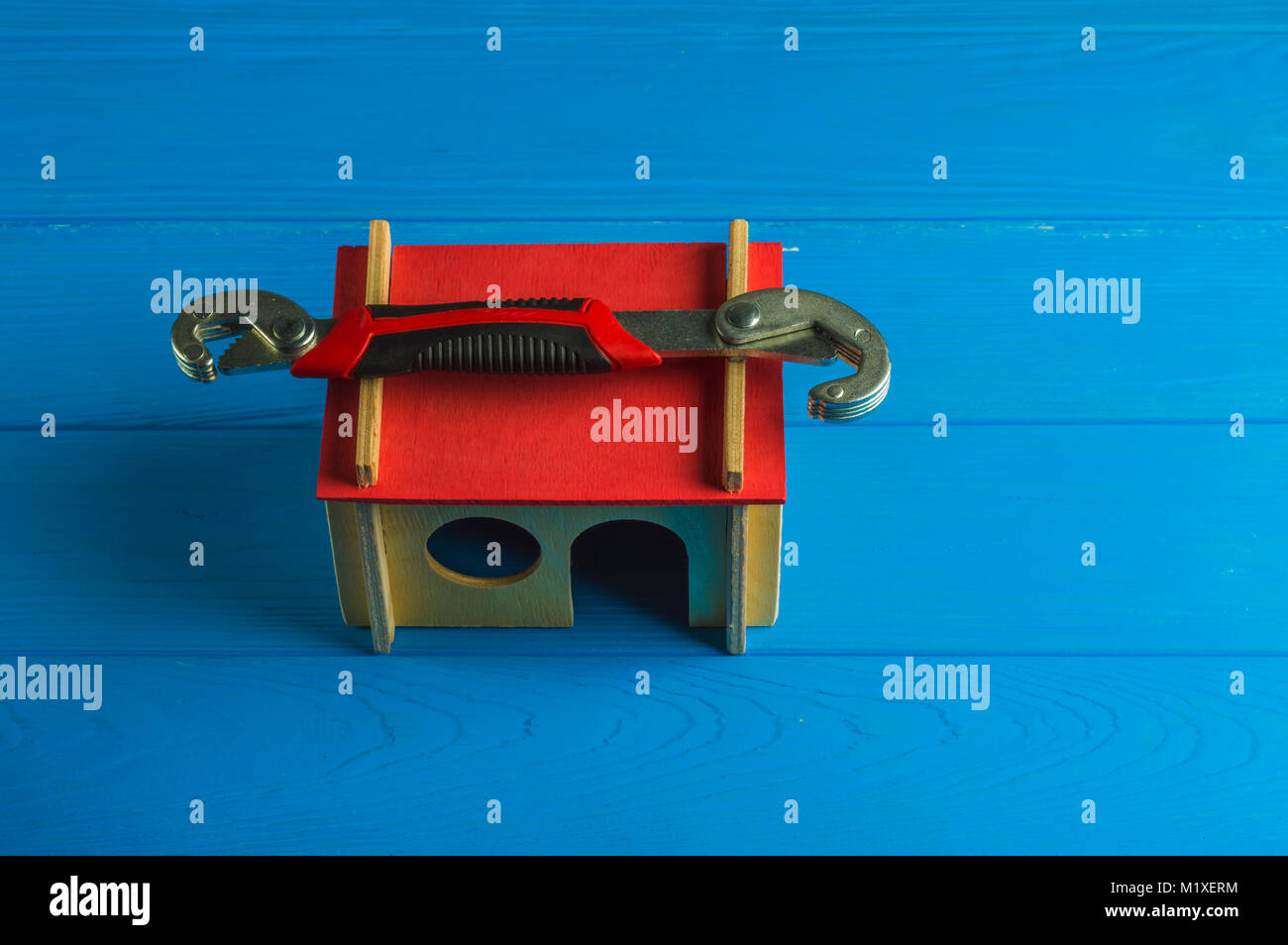 Monkey Wrench sul modello di casa a sfondo di legno Foto Stock