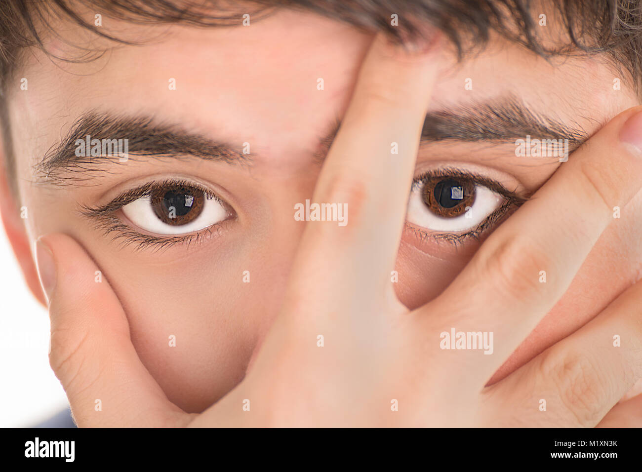 Extreme closeup del ragazzo adolescente con la mano sulla faccia Foto Stock