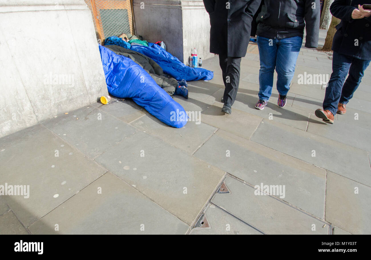 Londra, Inghilterra, Regno Unito. 3 senzatetto gli uomini sulla street nel centro di Londra - tre uomini a piedi passato Foto Stock