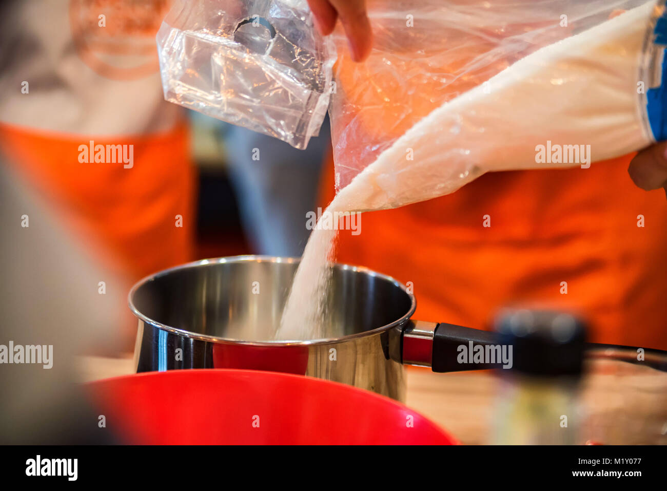 Aggiunta di zucchero in saucpan vicino Foto Stock