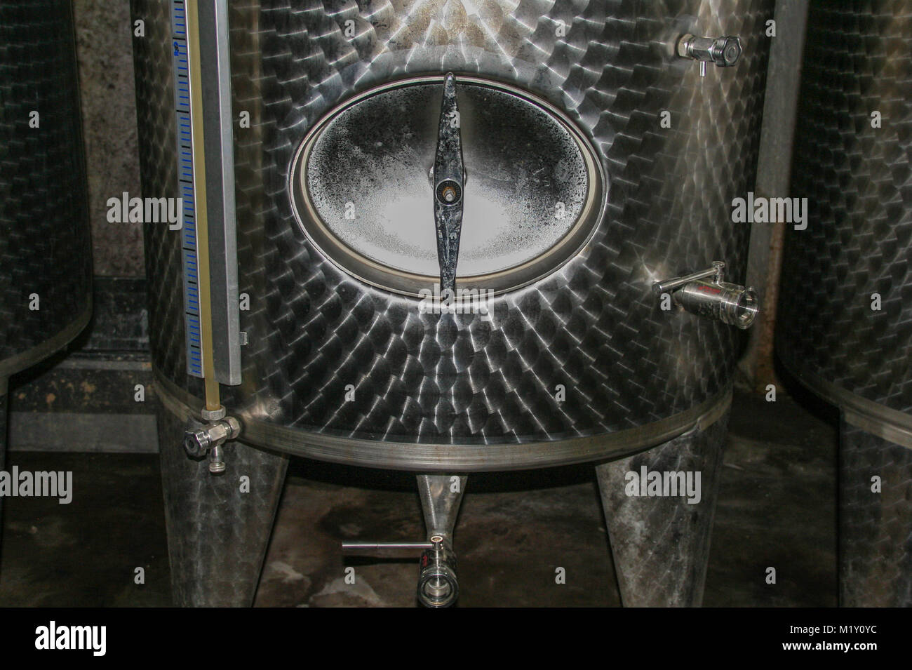 A TUFO - ITALIA - IL 11/ 19/2016 - dettaglio di una botte di vino tocca su una moderna vasca in una cantina Foto Stock