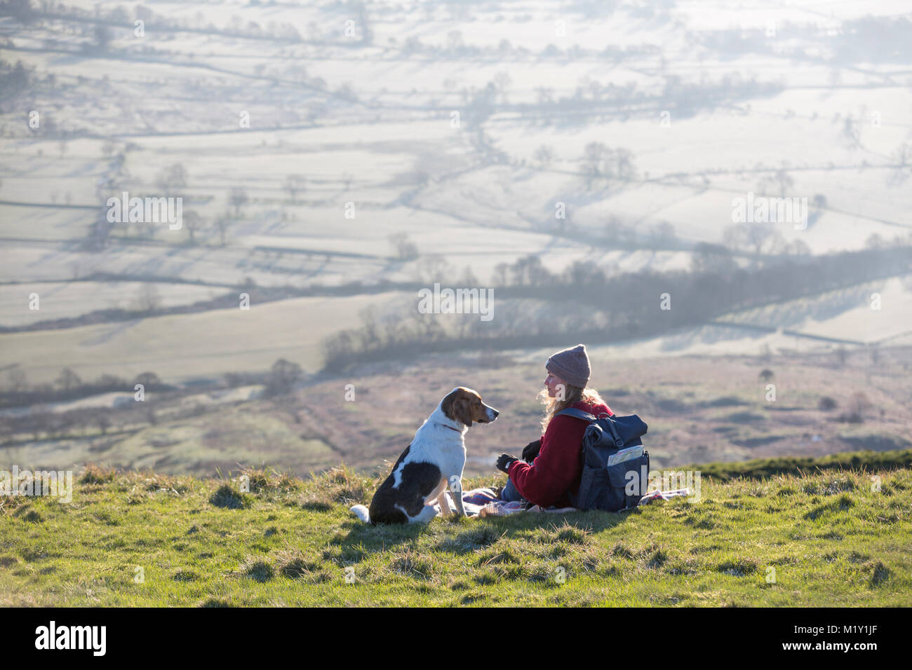 Regno Unito, Derbyshire, un walker e il suo cane, ammirando la vista sulla valle di speranza da Mam Tor. Foto Stock