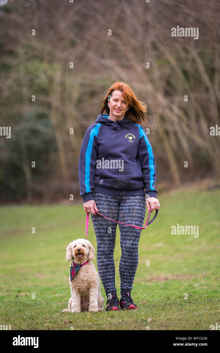 Piccolo cucciolo terrier cane con il suo proprietario femmina ina park REGNO UNITO Foto Stock